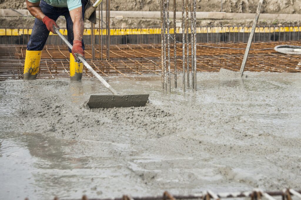 a bricklayers who level the freshly poured concrete to lay the foundations of a building
