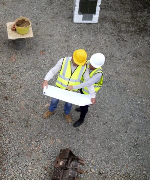 Construction site workers reviewing plans.